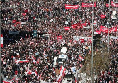 Protestors carry Lebanese flags and anti Syria banners during a street demonstration in Beirut, Lebanon Monday Feb. 21, 2005. Thousands of opposition supporters shouted insults at Syria and demanded the resignation of their pro-Syrian government, marking a week since the assassination of former Prime Minister Rafik Hariri. (AP Photo/str) 