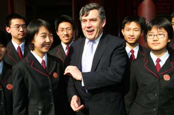 Britain's Chancellor of the Exchequer Gordon Brown chats with Chinese middle school students during his visit to China's capital Beijing February 21, 2005. Brown said on Monday that orderly capital account liberalisation was the way forward for modern economies, including China. 