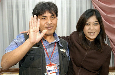 Two Indonesian journalists freed from militants in Iraq, Meutya Viada Hafid, right, and Budiyanto, who like many Indonesians goes by one name, wave after a press conference at the Indonesian Embassy in Amman, Jordan on Tuesday, Feb 22, 2005. [AP]