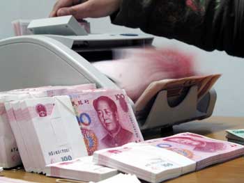 A bank clerk counts 100-yuan notes at a China Construction Bank office in Hai'an, Jiangsu Province in this February 23, 2005 photo. Guo Shuqing, chief of China's State Administration of Foreign Exchange, said China will gradually open its capital account in 2005, another step in its plan to make the yuan currency fully convertible. [newsphoto]