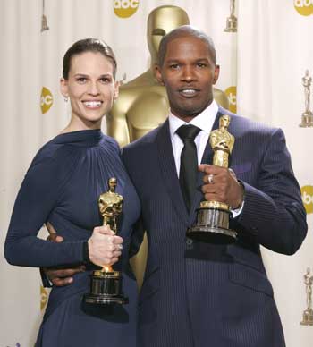 Actress Hilary Swank (L) and actor Jamie Foxx pose together with their Oscar statues at the 77th annual Academy Awards in Hollywood, February 27, 2005. Swank won the Academy Award for best actress for her role in "Million Dollar Baby" and Foxx won the Academy Award for best actor for his role in "Ray." [Reuters]