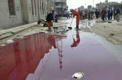 Iraqi workers clean debris near a large pool of blood at the scene of a suicide attack in the city of Hilla, February 28, 2005. A suicide bomber detonated a car near police recruits and a crowded market on Monday, killing 125 people and wounding 130 in the single bloodiest attack in Iraq since the fall of Saddam Hussein. [Reuters]