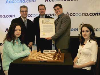 Chinese grandmaster Zhu Chen (left) and American rising star Irina Krush pose for a photograph before their Accoona Women's World Chess Championship game in New York on March 2, 2005. Standing at the left in the back row is Stuart Kauder, Accoon CEO. [chinadaily.com.cn]
