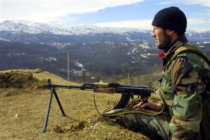 An officer of the Chechen presidential security service armed with a light machinegun, secures the village of Benoi during an ongoing military operation the Nozhai-Yurt district, 60 km (37 miles) southeast of Grozny in this Monday Feb. 28, 2005 photo. 'The operation is going on and it will continue until the entire gang is destroyed,' Ramzan Kadyrov, Chechnya (news - web sites)'s first deputy prime minister, was quoted as saying Saturday by ITAR-Tass. 'We will be fighting militants any place they threaten Russia, inside and outside Chechnya. Let their ringleaders and foreign sponsors know that this place is getting too hot for them.'(AP Photo/Musa Sadulayev) 