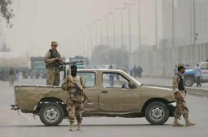 Iraqi soldiers stand guard in a street after car bombs exploded near Iraq's Interior Ministry in Baghdad March 3, 2005. Two car bombs exploded near Iraq's Interior Ministry in Baghdad on Thursday, killing at least five policemen and wounding several in violence that threatened to overshadow efforts to form a new government. [Reuters]