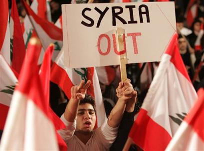A Lebanese opposition protester carries an anti-Syria banner, during their daily demonstration against Syria in Beirut, Lebanon, Friday March 4, 2005. Syrian President Bashar Assad is widely expected to announce a troop pullback to eastern Lebanon near the Syrian border but not a full withdrawal in a speech to his parliament on Saturday. [AP]