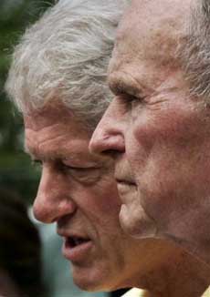 Former U.S. presidents Bill Clinton, left, and George H.W. Bush meet the media while inspecting rebuilding efforts for displaced residents from the December tsunami in Weligama, Sri Lanka Monday, Feb. 21, 2005. [AP] 
