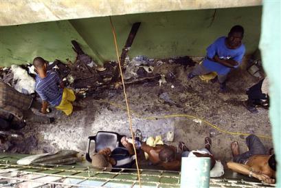 Prisoners survey the damage inside the public jail in Higuey, 103 miles to the east of Santo Domingo, Dominican Republic on Monday, March 7, 2005 following a fire that killed at least 133 people. (AP Photo/Miguel Gomez) 