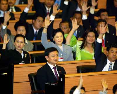 Members of parliament raise their hands to signal an acceptance of Thaksin Shinawatra's (C) nomination to become Thailand's Prime Minister in Bangkok March 9, 2005. Thailand's Parliament approved Thaksin for a second four-year term, following the former telecommunications tycoon's landslide victory at the polls last month. [Reuters]