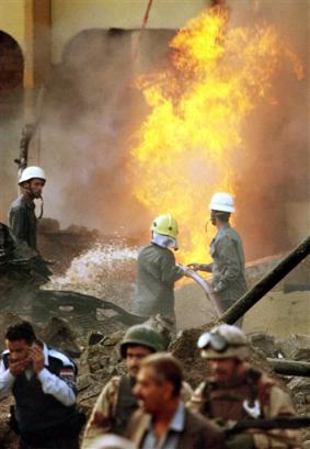 Firemen try to put out flames after a garbage truck exploded at dawn near a hotel used by western contractors in central Baghdad, Iraq Wednesday, March 9, 2005. The blast shook buildings and covered the area with acrid black smoke, and volleys of automatic weapons fire could be heard before and after the blast which occurred a few blocks from Firdous Square, the roundabout in central Baghdad where Iraqis toppled a statue of Saddam Hussein on April 9, 2003. [AP]
