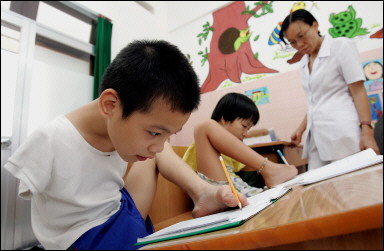 10-year-old Tran Binh Minhn (L) and 11-year-old Pham Thi Thuy Linh, both Agent Orange victims and handicap, learn to write with their feet at the Peace Village in Tu Du hospital in Ho Chi Minh City. Victims have angrily condemned a US court dismissal of their lawsuit against a string of US chemical firms alleging crimes against humanity. [AFP/File]