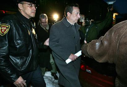Harvard University President Lawrence Summers, center, escorted by a Harvard police officer, left, departs a faculty meeting at Harvard, in Cambridge, Mass., Tuesday, March 15, 2005. Harvard's Faculty of Arts and Sciences passed a no-confidence vote against Summers on Tuesday, the latest setback for the embattled university leader who has come under fire for his managerial style and comments on women in science. [AP]