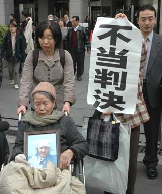 Guo Xicui (in wheelchair), 79, leaves the Tokyo high court March 18, 2005 after the court rejected her claims for compensation. She and many other Chinese women were forced to be sex slaves for the invading Japanese troops during the War of Resistance against Japan (1937-45). [Xinhua]