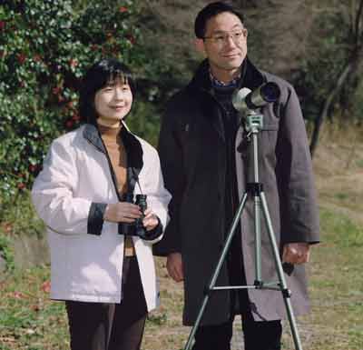 Japan's Princess Nori (L) and her fiance Yoshiki Kuroda enjoy bird-watching on the grounds of the Imperial Palace in Tokyo in this March 13, 2005 photo released by the Imperial Household Agency on March 18, 2005. The couple will observe an imperial court ceremony for engagement on Saturday. Photo taken March 13, 2005. [Reuters]