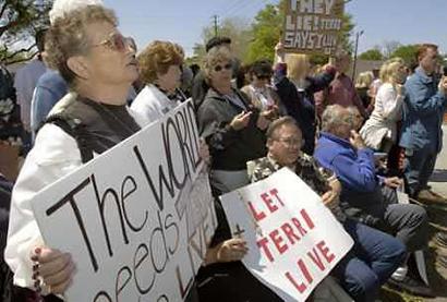 Protesters in support for Terri Schiavo gather outside Woodside Hospice in Pinellas Park, Florida on March 18, 2005. A Florida court cleared the way to remove the feeding tube that sustains a severely brain-damaged woman after U.S. lawmakers tried to prolong her life by subpoenaing her to appear before Congress. Photo by Stringer/Usa/Reuters 