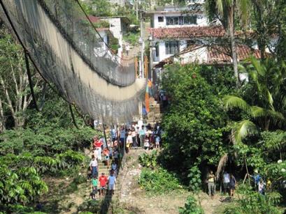 People look at a hanging bridge that collapsed on one side during a festival in the town of Tapijulapa, Mexico on Sunday March 20, 2005. At least four people died and 37 people were injured in the incident.(AP Photo/Luis Lopez) 