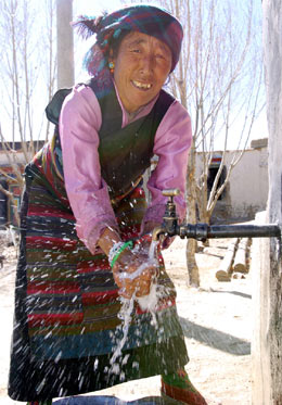 Farmer Puchi 
 washes 
 her hands with tap water outside her home in Xigaze, the Tibet Autonomous Region March 22, 2005. The central government has injected 400 million yuan in providing 500,000 Tibetans with clean drinking water since 2001. [Xinhua]