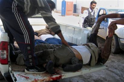 The bodies 
 of 
 three men are removed after they were killed in clashes between insurgents and armed local residents in the Dora section of Baghdad, Iraq, Tuesday, March 22, 2005. Iraqi Police were also involved in the firefight, witnesses said. [AP]