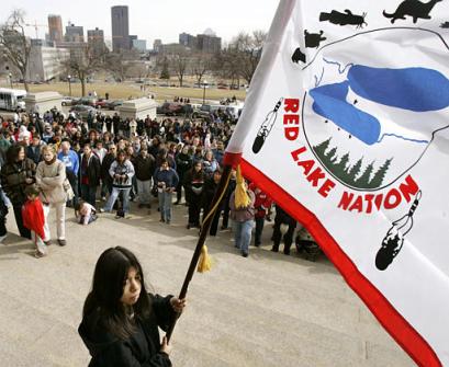A flag-bearer 
 gathers 
 with several hundred people for a traditional American Indian prayer service on the steps of the State Capitol in St. Paul, Minn., Tuesday, March 22, 2005. The prayer service which was held in response to the shootings at Red Lake (Minn.) High School on Monday. Jeff Weise killed nine people at the school, including five students, before killing himself. [AP]