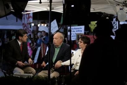 Bob Schindler and Mary Schindler give an interview to a television station while surrounded by protestors on Wednesday, March 23, 2005 in Pinellas Park, Fla. The Schindler's are fighting a public fight to try and save their daughter Terri Shiavo. (AP Photo/Evan Vucci)