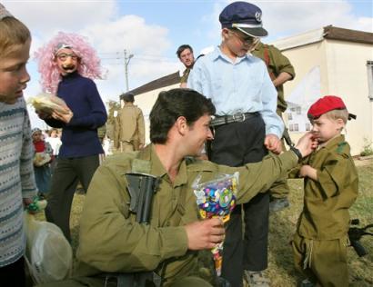 An Israeli soldier pinches the cheek of a boy dressed in a soldier's costume in the Jewish settlement of Netzarim in the Gaza Strip (news - web sites), during the celebrations of Purim Wednesday March 23, 2005. Opponents of Israel's planned withdrawal from the Gaza Strip lost a major weapon in their arsenal Wednesday after a key religious figure stood firm by his refusal to support a referendum on the pullout. (AP Photo/Tsafrir Abayov)