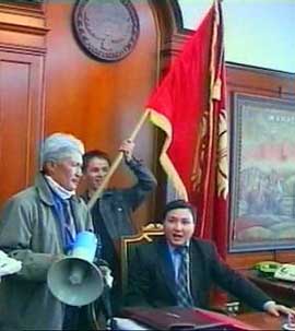 In this image taken from video an opposition leader, Ulan Shambetov, surrounded by supporters, sits in Kyrgyz President Askar Akayev's chair in presidential headquarters in Bishkek, Kyrgyzstan, Thursday, March 24, 2005. Protesters stormed the presidential compound in Kyrgyzstan on Thursday, seizing control of the main symbol of state power after clashing with riot police surrounding it during a large opposition rally. (AP