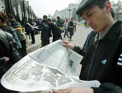 A Kyrgyz man reads a newspaper in front of the presidential office in central Bishkek, March 25, 2005. A Kyrgyz opposition leader called for calm on Friday after protests that plunged into violence and looting that left the capital strewn with broken glass and blood. [Reuters]