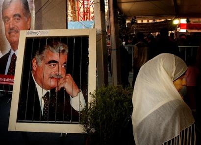 A Lebanese woman stands by posters of slain former Lebanese Prime Minister Rafik Hariri at the grave in Martyrs' Square at central Beirut, Lebanon, on Friday, March 25, 2005. A U.N. report into the killing of former Lebanese Prime Minister Rafik Hariri demanded a new international investigation after determining that Lebanon's authorities bungled, if not outright manipulated, their probe of the killing. (AP Photo / Petros Karadjias)