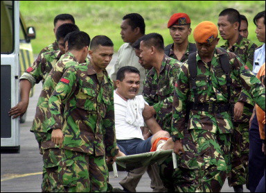 Indonesian troops evacuate an injured villager from Nias island. A lack of earth-moving gear on the isolated Indonesian islands closest to the epicentre of this week's massive earthquake means that many may perish trapped beneath the rubble(AFP/ATAR) 