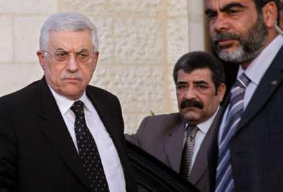 Palestinian President Mahmoud Abbas (L) arrives at his headquarters in the West Bank city of Ramallah, March 30, 2005. REUTERS/Loay Abu Haykel 