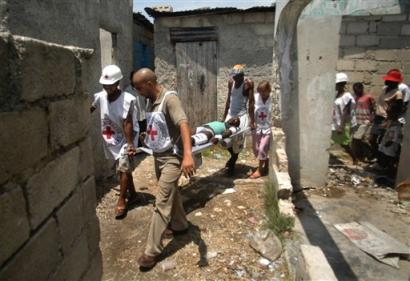 Red cross workers evacuate an injured man whom residents said was shot during a raid by Haitian police and peacekeepers last night in Cite-Soleil, a slum in Port-au-Prince, Haiti, Monday, April, 4, 2005. (AP Photo/Evens Sanon)