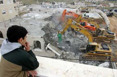 A Palestinian boy looks at a house destroyed by Israeli troops, because it was built without permission, in east Jerusalem April 4, 2005. Israeli Prime Minister Ariel Sharon pledged on Monday to push ahead with expansion of a large Jewish settlement near Jerusalem, despite U.S. concerns and Palestinian protests that it would cut them off from the city. (Mahfouz Abu Turk/Reuters) 