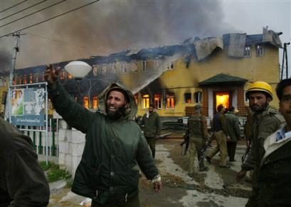 A Jammu Kashmir Fire Fighter shouts for help as smoke engulf the Tourist Reception Center after militants attacked it in Srinagar, India, Wednesday, April 6, 2005. Two suicide attackers opened fire and forced their way into the government guest house, where more than two dozen passengers of the first Indian-Pakistan bus across Kashmir were being held under protective custody, police and witnesses said.(AP Photo/Rafiq Maqbool)