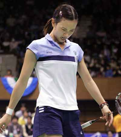 France's Pi Hongyan reacts after missing a shot during the women's badminton singles semi-finals match against China's world number one Xie Xingfang at the Japan Open in Tokyo April 9, 2005. [Reuters]