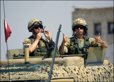 British soldiers give the thumbs-up as they guard the gates of the newly opened soccer stadium in the southern city of Basra, 500 kms from Baghdad. The stadium was repaired and made ready for use in a joint British-Iraqi scheme(AFP/Essam Al-Sudani) 