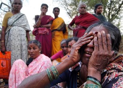 Akkaiyamma, right, mother of Kalaiah, 25, mourns during the last rites of her son at Mathahalli village, 25 kilometers (16 miles) northwest of Bangalore, India, Tuesday, April 12, 2005. Kalaiah was one of twenty people, who died after drinking contaminated liquor sold by a shopkeeper. (AP Photo/Gautam Singh) 