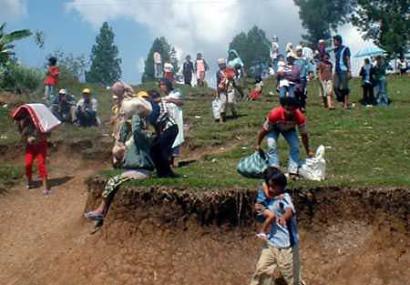 Villagers of Bukit Sileh village carry their belongings as they evacuate after Mt. Talang volcano erupted in Solok district of Indonesia's West Sumatra island, April 12, 2005. More than 25,000 panicked residents have been evacuated from the slopes of a rumbling volcano on Indonesia's Sumatra island and officials raised the alert level on April 13 as the mountain's activity intensified. (Stringer/Indonesia/Reuters)