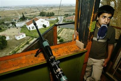 An Israeli boy stands in a watchtower overlooking the Jewish settlement of Morag in the southern Gaza Strip Wednesday April 13, 2005. Israeli Prime Minister Ariel Sharon has offered to leave homes in the Gaza strip settlements intact if the Palestinians cooperate with Israel during the Gaza pullout this summer. Israel had initially planned to raise all 21 Gaza Strip settlements and four more in the West Bank to the ground after evacuating some 9,000 settlers from their homes under Sharon's disengagement plan. (AP Photo/Oded Balilty) 