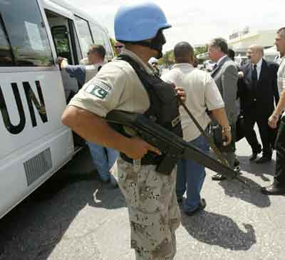 UN Special Representative to Haiti Juan Gabriel Valdez (C-Rear) and Brazil Permanent Representative to the UN Ronaldo Mota Sardenberg (R-Rear) are guarded by UN peacekeeping troops as they leave Toussaint Louverture International Aiport in Tabarre, Haiti after arriving in Haiti on April 13, 2005. The UN Security Council sent the mission to Haiti in order to evaluate the UN peacekeeping mission progress. [Reuters]