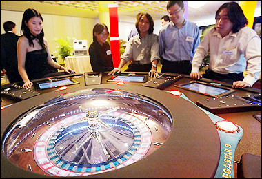 Visitors try out the roulette game at a gaming and casino exhibition in Singapore in 2003. The issue of gambling in Singapore has flared into the spotlight over recent months amid a public debate over the government's proposal to approve the building of the city-state's first casino.(AFP/File