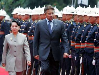 Philippine President Gloria Macapagal Arroyo (L) walks with visiting Pakistani President Pervez Musharraf as they review troops during the welcoming ceremony at the Presidential Palace in Manila April 19, 2005. Musharraf arrived in the Philippines on Monday for a three-day visit expected to focus on cooperation against Muslim militancy and the the U.S.-led war against terrorism. REUTERS