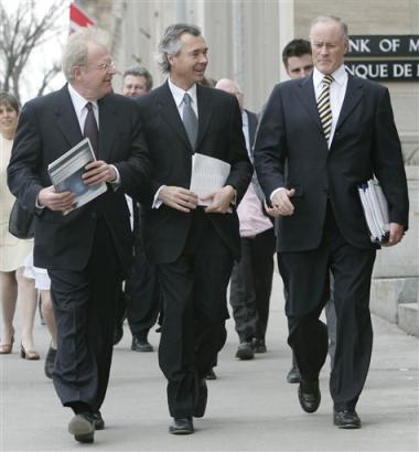 Trade Minister Jim Peterson, left, and Foreign Affairs Minister Pierre Pettigrew look over towards Defense Minister Bill Graham upon their arrival for a news conference in Ottawa, Tuesday April 19, 2005 to announce Canada's international policy statement. (AP