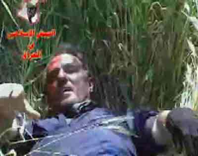 A video grab from footage released on the internet by an Iraqi insurgent group on April 21, 2005 a man in blue overalls lying in a grassy area at an undisclosed location in Iraq. An Iraqi insurgent group said it shot down a commercial helicopter with 11 people on board on Thursday and then killed the only survivor, according to a statement and video posted on the Internet. [Reuters]