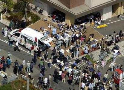 Injured people are tended to after a derailed commuter train smashed into an apartment building in Amagasaki, western Japan April 25, 2005, killing two people and injuring many others, reports said. Nearly 140 people have been hurt, reports said. 