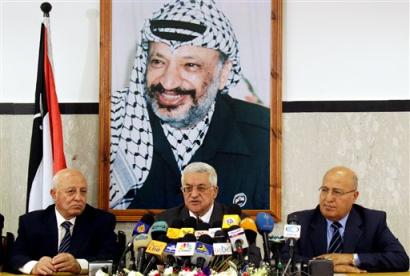 Palestinian Authority President Mahmoud Abbas, also known as Abu Mazen, center, sits with Prime Minister Ahmed Qureia, left and Deputy Prime Minister Nabil Shaath, right, as he talks to the media during a news conference at his office in Gaza City, Monday April, 25, 2005. Abbas said Monday he expects the militant group Hamas to hand in its weapons after joining the Palestinian parliament this summer, but gave no indication he would forcefully disarm the militant group. (AP