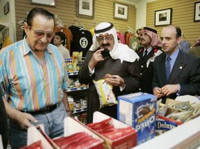 Saudi Arabia's Crown Prince Abdullah (C) shops for snacks at the Coffee Station restaurant and store alongside store owner Nick Spanos (L) and foreign affairs advisor to the Crown Prince, Adel Al-Jubeir (R) in Crawford, Texas, April 25, 2005. Earlier in the day U.S. President George W. Bush hosted the Crown Prince on his Crawford ranch where they discussed the Saudi kingdom's efforts to fight terrorism and seek its help in countering the economic threat posed by record oil prices. REUTERS