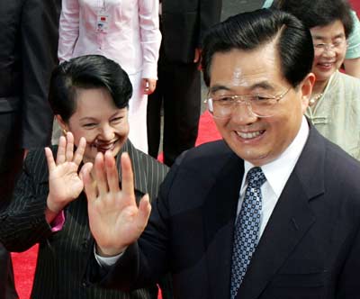 Philippine President Gloria Macapagal Arroyo (L) and visiting Chinese President Hu Jintao wave to well wishers during a welcome ceremony at the presidential palace in Manila April 27, 2005. [Reuters]