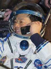 U.S. astronaut Leroy Chiao speaks on a satellite phone in Arkalyk airport in northern Kazakhstan April 25, 2005.