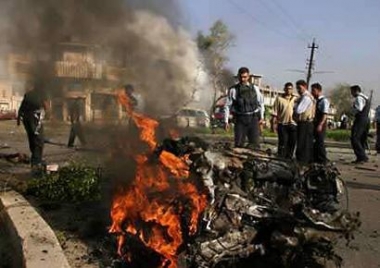 Policemen look at remains of a car that was used in a suicide bomb attack in the Athamiya district of Baghdad April 29, 2005. A string of car bombs killed at least 29 people in Iraq on Friday, ramming home to the new government in Baghdad that insurgents are as strong as ever. REUTERS