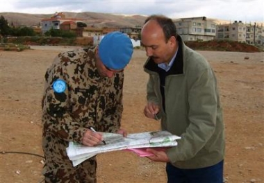 One of a nine-member U.N. team, left, charged with verifying Syria's troop withdrawal from Lebanon, checks a map with a Lebanese intelligence officer as they inspect intelligence offices and troop bases vacated by Syrian forces in Baalbek, Lebanon, Tuesday May 3, 2005. A verification team sent by the U.N. Security Council began its mission on the ground Tuesday, inspecting military bases vacated by Syrian forces in the eastern Bekaa Valley city of Baalbek.(AP